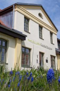 a building with blue flowers in front of it at Ferienwohnungen - barrierefrei - im sanierten Gutshof in Lalendorf