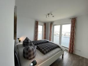a bedroom with a bed with pillows and a window at Schleivilla Lootsen Hus by Seeblick Ferien ORO, 3Etagen,8Pers,Sauna,Kamin in Olpenitz