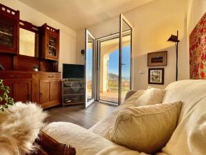 uma sala de estar com um sofá e uma porta de vidro deslizante em 3-room apartment with sea view, A/C & Free Parking em Ranzi