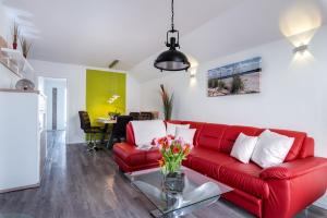 uma sala de estar com um sofá vermelho e uma mesa em Fewo Kapitän James Cook by Seeblick Ferien ORO, Wasserbett, E-Ladesäule, em Olpenitz