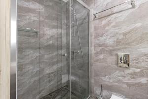 y baño con ducha y puerta de cristal. en Yes apartments en Astaná