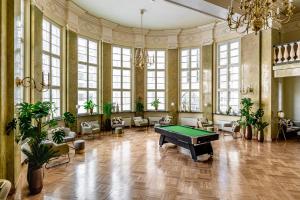 a pool table in a large room with windows at MILESTONE Krakow Center Urban Living in Krakow