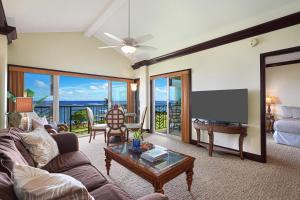 een woonkamer met een bank en een flatscreen-tv bij Waipouli Beach Resort G-404 in Kapaa