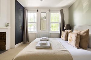 a bedroom with a large bed with two towels on it at The Stratford Villas in London