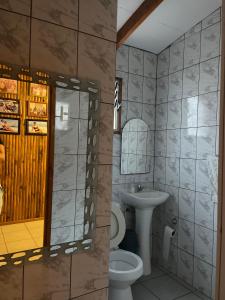 ein Badezimmer mit einem Waschbecken, einem WC und einem Spiegel in der Unterkunft Casa marejada in Caldera