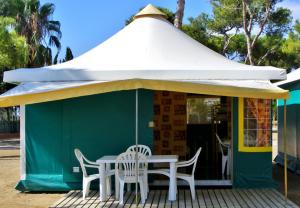 a green and white tent with chairs and a table at Camping Relax Sol in Torredembarra