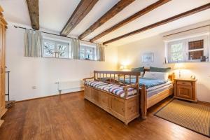 - une chambre avec un lit en bois et 2 fenêtres dans l'établissement Ferienwohnung Juttashof, 