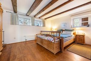 a bedroom with a wooden bed and two windows at Ferienwohnung Juttashof in Camin