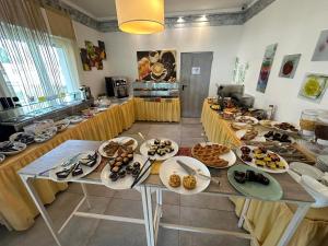 une table avec de nombreuses assiettes de nourriture dans l'établissement Hotel Irene, à Lignano Sabbiadoro