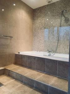 a bathroom with a bath tub and a shower at Ye Olde Nags Head in Castleton