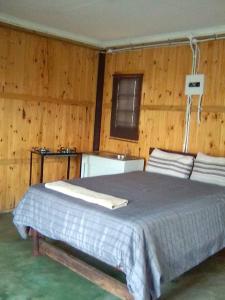 a bedroom with a bed in a wooden wall at Inkwazi Getaway Lodge in Manzini