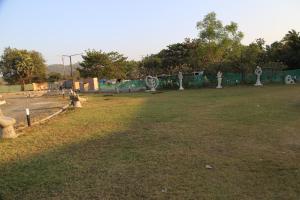a park with some statues in the grass at Suryaansh in Pālghar