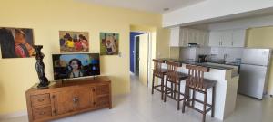 - une cuisine avec un îlot doté d'une télévision dans l'établissement VIP Condochain Rayong, à Ban Chamrung