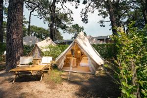 a tent with a table and chairs in a yard at Kampaoh Bayona Playa in Baiona
