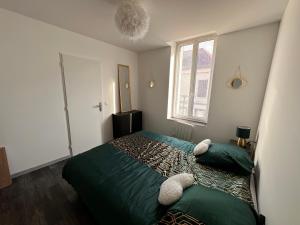 un dormitorio con una cama con dos animales de peluche en Appart cocooning, en Saint-Germain-des-Fossés