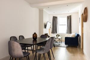 une salle à manger avec une table et des chaises noires dans l'établissement The Stratford Villas, à Londres