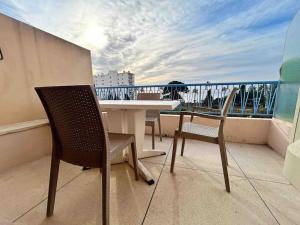 balcón con mesa y sillas en Le Dulys : Apt 2 prs, vue mer, clim, 2 min plages en Antibes