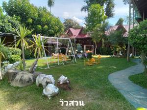 a yard with a swing set and a playground at เรือนแฝด Brook view in Pai