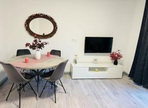 una sala da pranzo con tavolo, TV e specchio di StephBy Home a Kaiserslautern