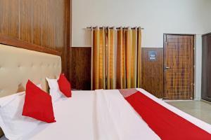 a bedroom with a large bed with red pillows at OYO Flagship Hotel CZ Inn in Lucknow