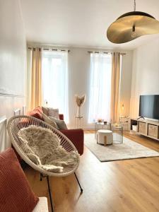 una sala de estar con un sofá y una silla en Appartement avec magnifique vue sur la Saône et son balcon, en Chalon-sur-Saône