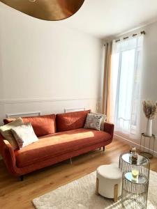 Una sala de estar con un sofá marrón y una mesa. en Appartement avec magnifique vue sur la Saône et son balcon, en Chalon-sur-Saône