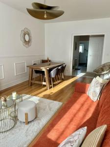 a living room with a couch and a table at Appartement avec magnifique vue sur la Saône et son balcon in Chalon-sur-Saône +27 photos