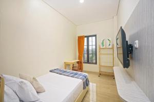 um quarto com uma cama e uma televisão em Habitat@Gandaria em Jakarta