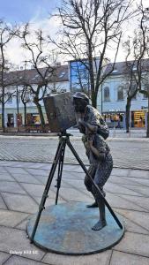 eine Statue einer Person mit Kamera auf einem Stativ in der Unterkunft KaunasInn LA in Kaunas