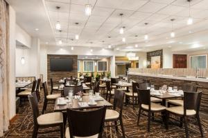 a dining room with tables and chairs and a television at Holiday Inn Gaithersburg by IHG in Gaithersburg