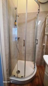 a shower with a glass door in a bathroom at KaunasInn LA in Kaunas