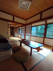 una camera con tavolo e alcune finestre di そらやまゲストハウス Sorayama guesthouse a Ino
