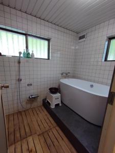いの町にあるそらやまゲストハウス Sorayama guesthouseのバスルーム(白いバスタブ、シャワー付)