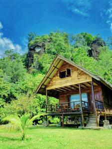 a house with a deck and a mountain at Ricky's Beach House in Pasarsungai-nyala
