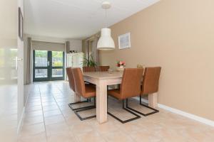 a dining room with a table and chairs at Duynopgangh 25 in Julianadorp