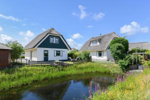 a house with a pond in front of a house at Duynopgangh 25 in Julianadorp