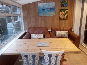 a living room with a wooden table and a couch at Beautiful 3-Bed Bungalow Kessingland rural retreat in Lowestoft