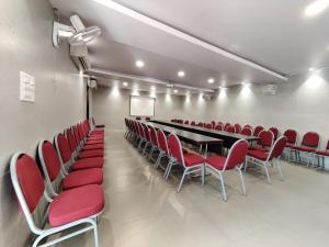 a conference room with a long table and red chairs at Annandam Inn(Hotel Anand) in Seonī