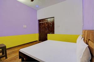 een slaapkamer met een bed en een houten deur bij Super OYO New Paradise Guest House 