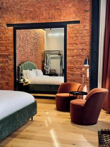 a bedroom with two beds and chairs and a mirror at RUZ Hotels in Istanbul