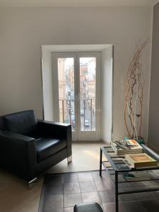 uma sala de estar com um sofá preto e uma mesa de vidro em Suite Artis Barberini em Roma