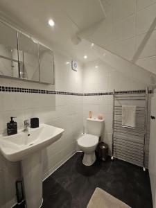 a white bathroom with a sink and a toilet at Brook Green 2 bed flat in London