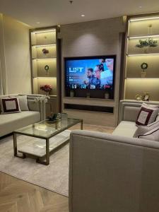 a living room with a couch and a tv at شقة فاخرة بمدخل طراز سلماني in Riyadh