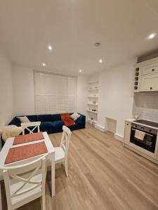 a living room with a table and a blue couch at Brook Green 2 bed flat in London