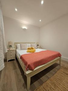 a bedroom with a bed with a yellow blanket on it at Brook Green 2 bed flat in London