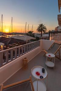 einen Balkon mit Tischen und Stühlen und Hafenblick in der Unterkunft Casa di Grazia in Naxos Chora