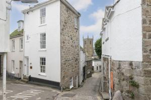an alley in the medieval town of hastings with a tower at Tathra Beach Cottage in St Ives