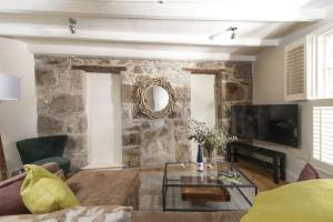 a living room with a stone wall at Tathra Beach Cottage in St Ives