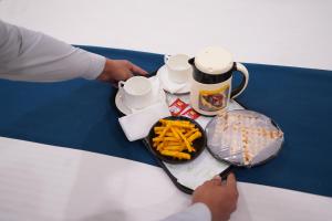 uma mesa com um prato de batatas fritas e uma bebida em Hotel Lyf Corporate Suites - Peera Garhi em Nova Deli