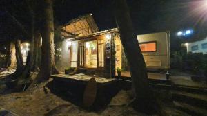 una pequeña casa con árboles alrededor de ella por la noche en Maliblues Bed & Art Gallery en Chumphon